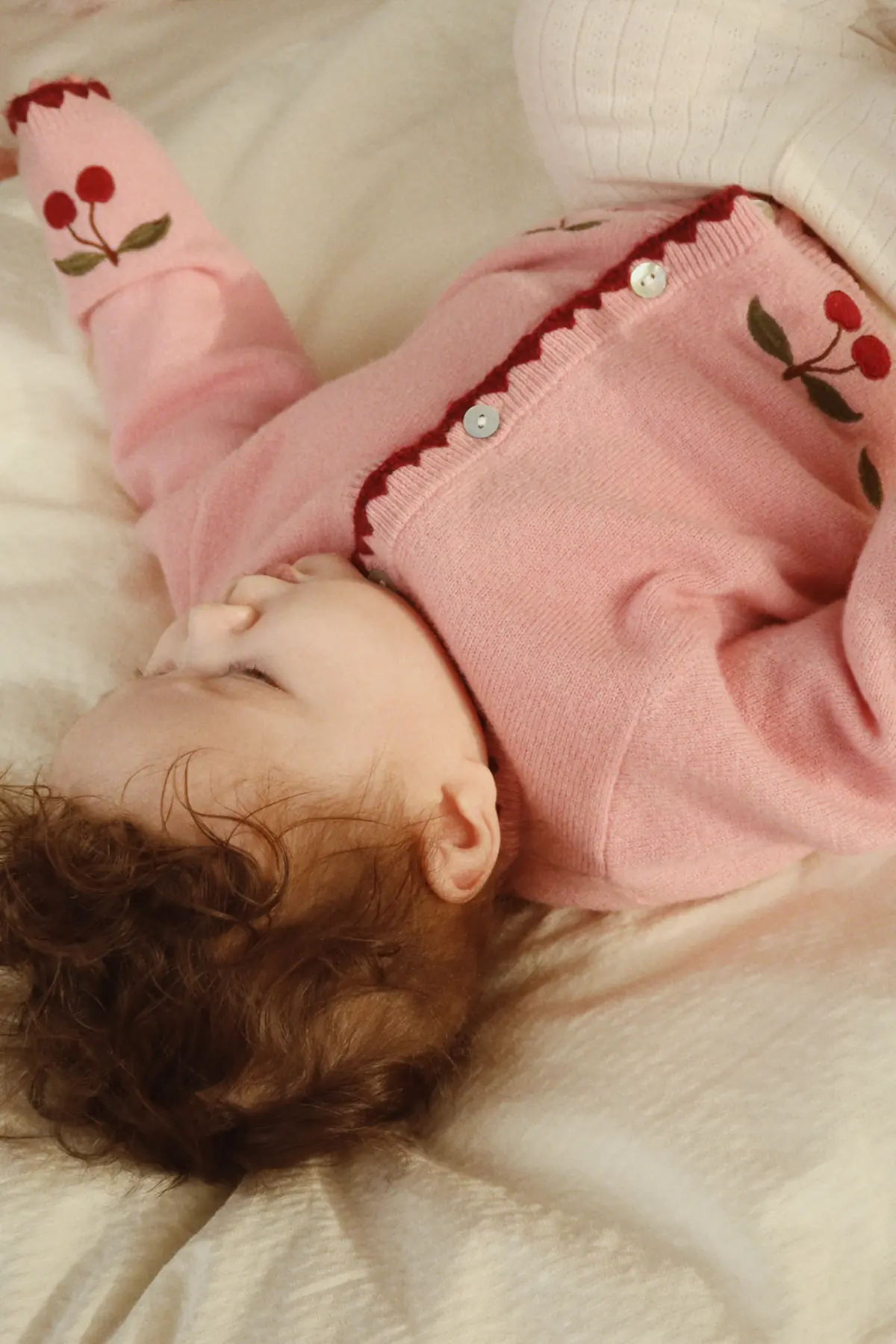 Konges Sløjd Strickjacke Collette „Pale Blush“ – Strickjacke zum Liegen getragen